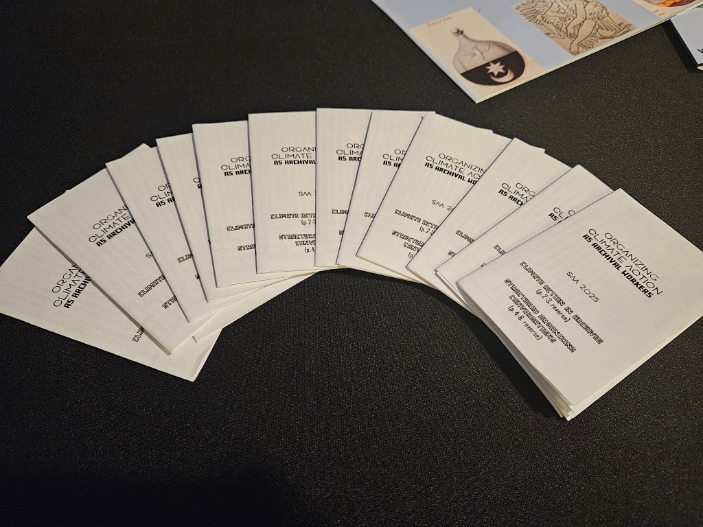 A group of zines fanned out on a table with a black tablecloth